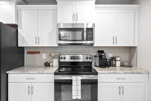 kitchen featuring stainless steel appliances, white cabinetry, and light stone countertops