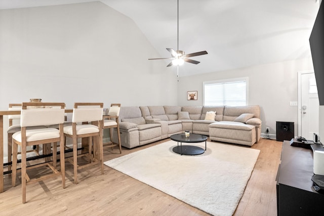 living room featuring vaulted ceiling, ceiling fan, and light hardwood / wood-style flooring