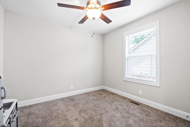 carpeted spare room featuring ceiling fan