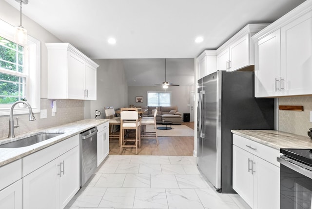 kitchen with appliances with stainless steel finishes, sink, and white cabinets