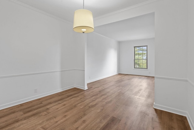 empty room with hardwood / wood-style flooring and crown molding