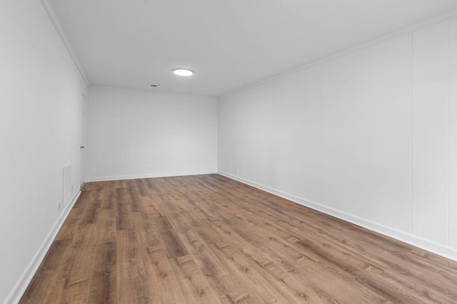 empty room with crown molding and wood-type flooring