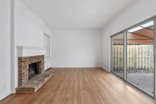 unfurnished living room with crown molding, hardwood / wood-style floors, built in features, and a fireplace