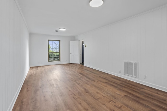 unfurnished room with crown molding, hardwood / wood-style floors, and wood walls