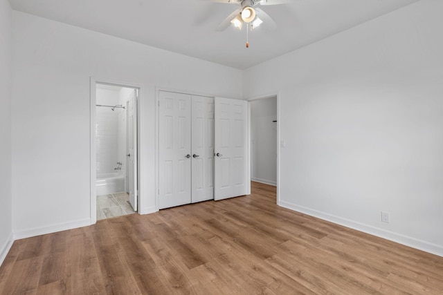 unfurnished bedroom with connected bathroom, a closet, ceiling fan, and light wood-type flooring