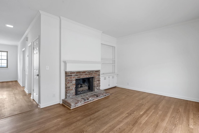 unfurnished living room featuring ornamental molding, a brick fireplace, and hardwood / wood-style floors