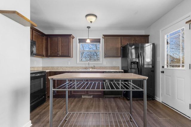 kitchen with pendant lighting, sink, dark brown cabinets, and black appliances