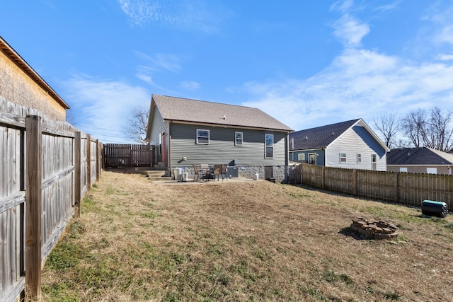 back of property featuring a fire pit and a lawn