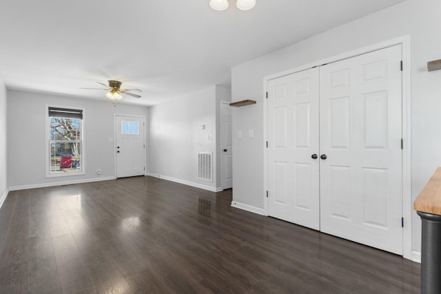 interior space featuring dark wood-type flooring and ceiling fan