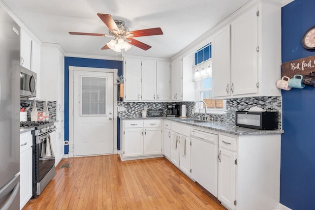 kitchen featuring white cabinetry, sink, stainless steel appliances, crown molding, and light wood-type flooring