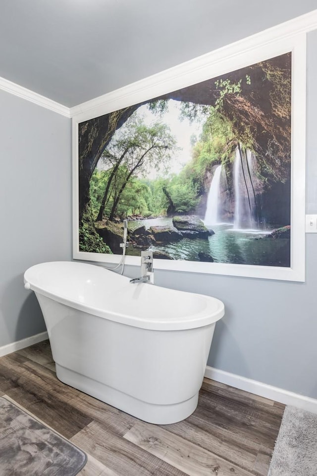 bathroom featuring hardwood / wood-style flooring, ornamental molding, and a washtub