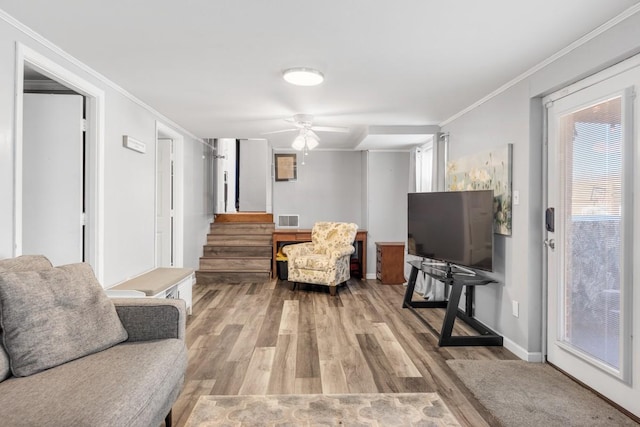 living room featuring crown molding, light hardwood / wood-style flooring, and ceiling fan