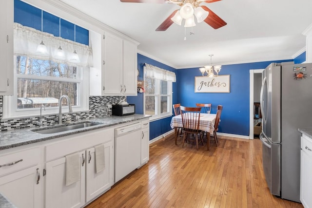 kitchen with sink, decorative light fixtures, stainless steel refrigerator, dishwasher, and white cabinets