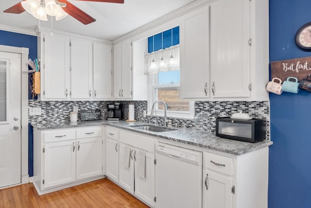 kitchen featuring white dishwasher, sink, light hardwood / wood-style flooring, and white cabinets