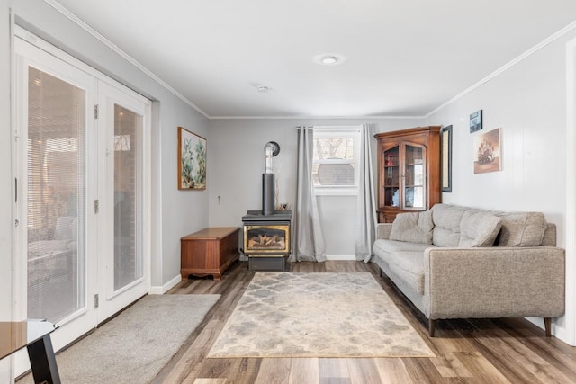 living room with hardwood / wood-style flooring, crown molding, and a wood stove