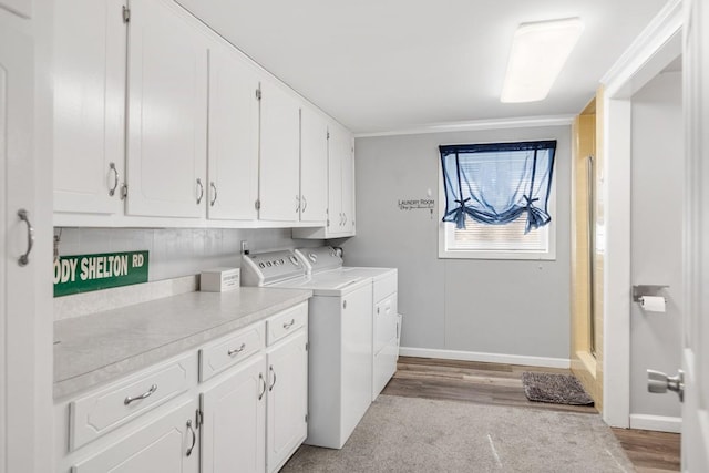 washroom with washer and dryer and cabinets