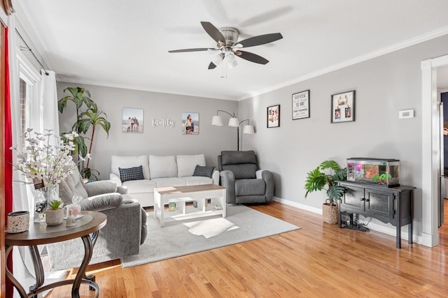 living room with wood-type flooring, ornamental molding, and ceiling fan