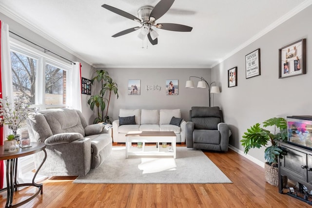 living room with wood-type flooring, ornamental molding, and ceiling fan