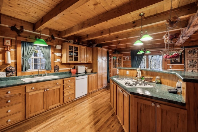 kitchen with sink, decorative light fixtures, beamed ceiling, white appliances, and light hardwood / wood-style floors