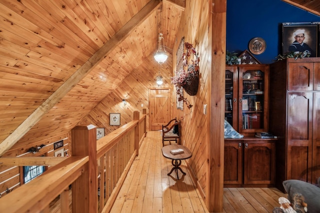 interior space with wood ceiling, vaulted ceiling with beams, light hardwood / wood-style flooring, and wood walls