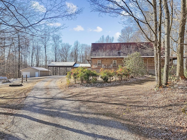 view of front of home featuring a garage, a carport, and an outbuilding