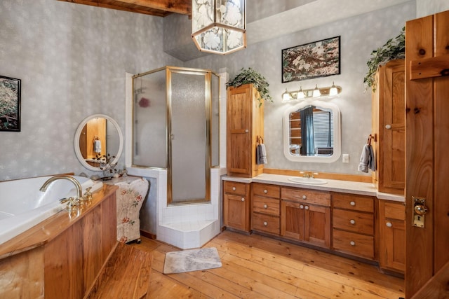 bathroom with wood-type flooring, separate shower and tub, and vanity