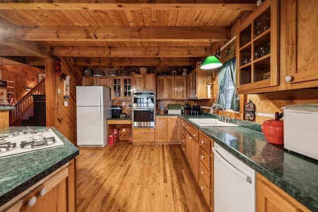 kitchen with pendant lighting, sink, white appliances, and beamed ceiling