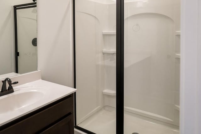 bathroom featuring vanity and a shower with door