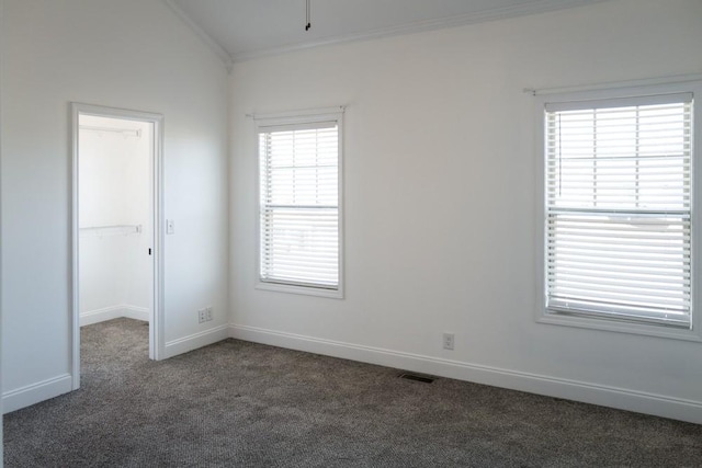 carpeted spare room featuring ornamental molding and vaulted ceiling