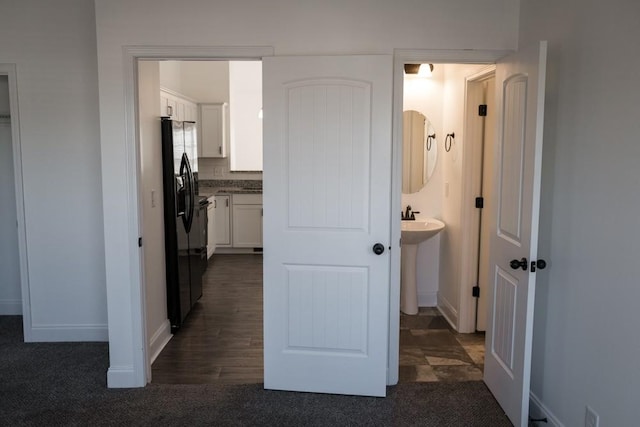 hallway featuring dark colored carpet