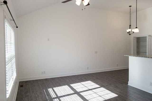 unfurnished living room featuring vaulted ceiling, dark wood-type flooring, and ceiling fan with notable chandelier