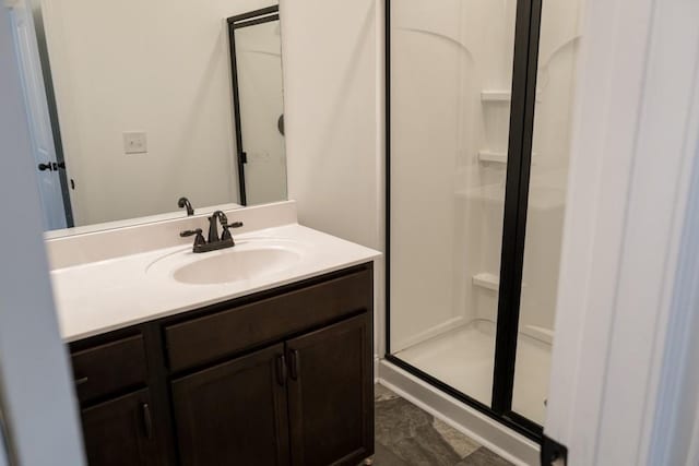 bathroom featuring vanity and a shower with shower door