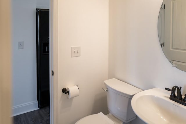 bathroom with hardwood / wood-style flooring, sink, and toilet