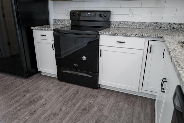 kitchen featuring white cabinetry, light stone countertops, black appliances, and hardwood / wood-style floors