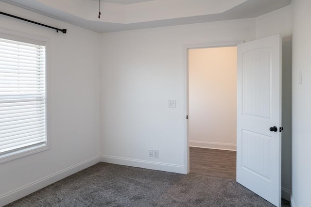 spare room with dark colored carpet