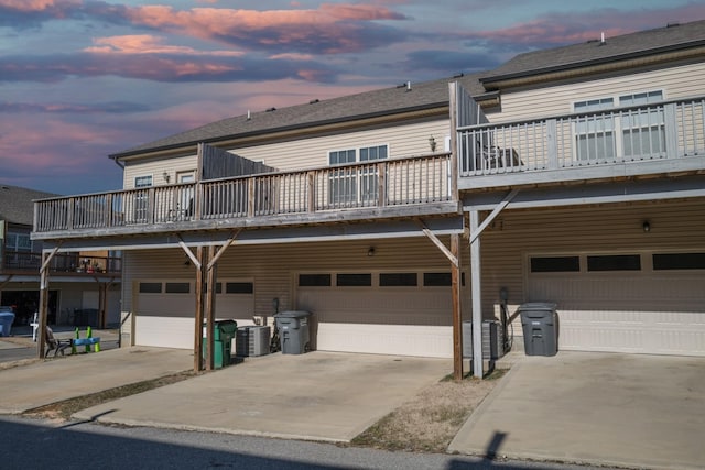 exterior space featuring cooling unit, a garage, and a balcony