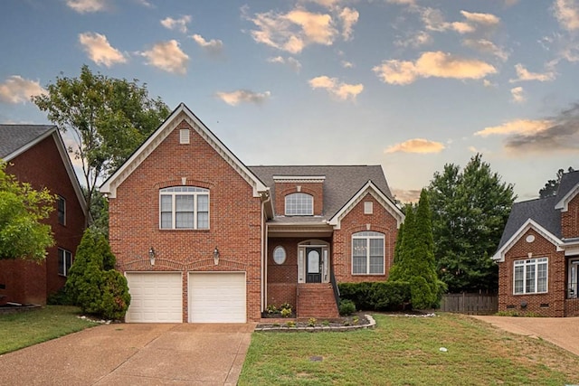 front of property with a garage and a yard