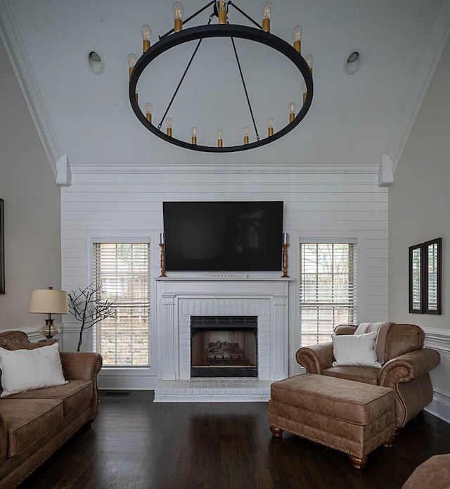 living room featuring crown molding, dark hardwood / wood-style floors, a healthy amount of sunlight, and a fireplace