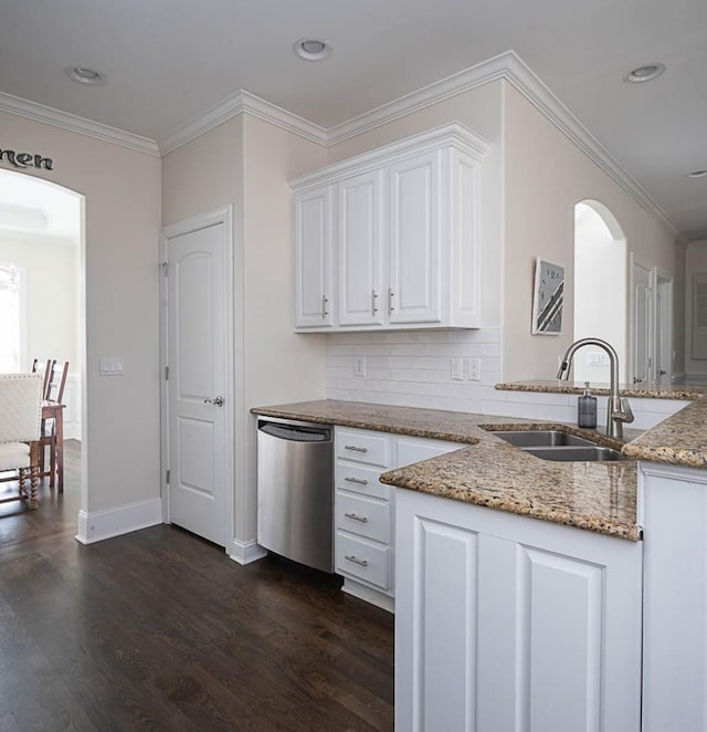 kitchen featuring sink, white cabinets, backsplash, stainless steel dishwasher, and light stone countertops