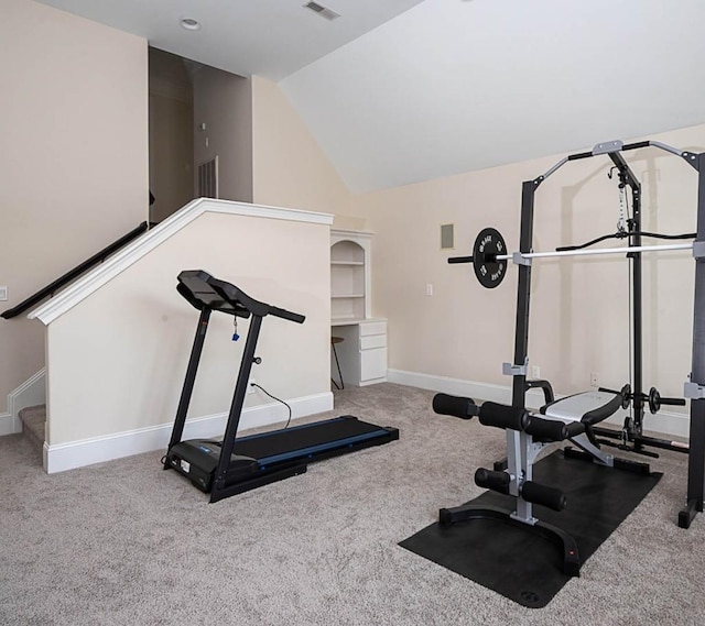 exercise room featuring light colored carpet and vaulted ceiling