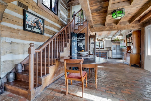 dining space with wooden ceiling and wood walls