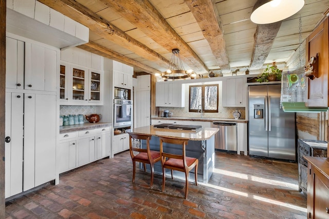 kitchen with tasteful backsplash, white cabinetry, and appliances with stainless steel finishes