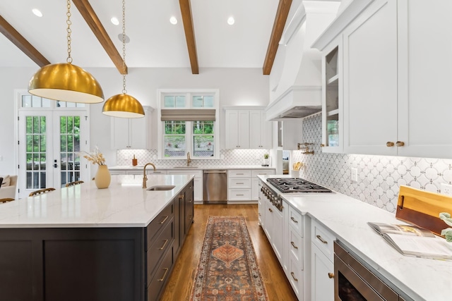 kitchen featuring pendant lighting, sink, a kitchen island with sink, and white cabinets