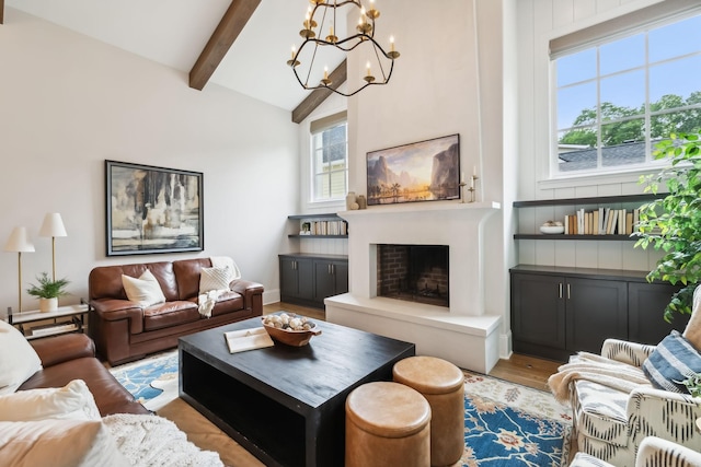 living room with beamed ceiling, a chandelier, and light wood-type flooring