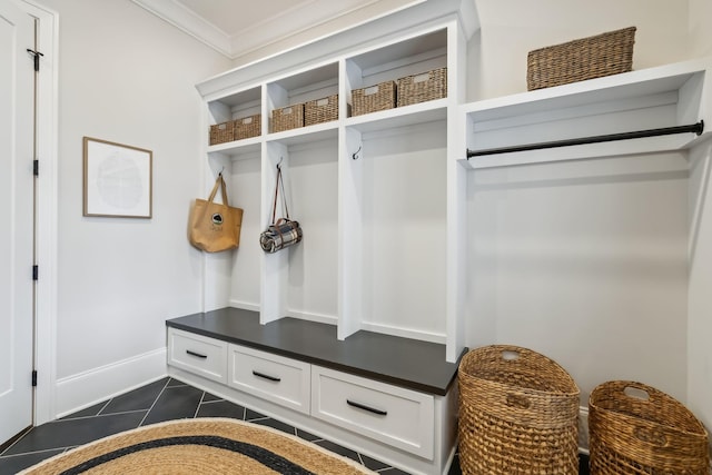 mudroom featuring crown molding and dark tile patterned flooring