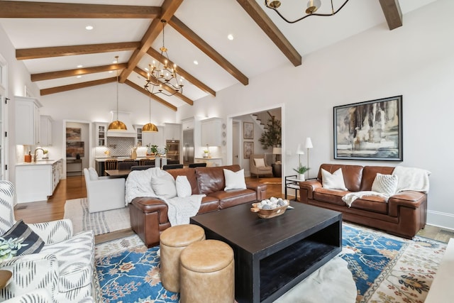 living room with dark hardwood / wood-style flooring, a chandelier, sink, and beam ceiling