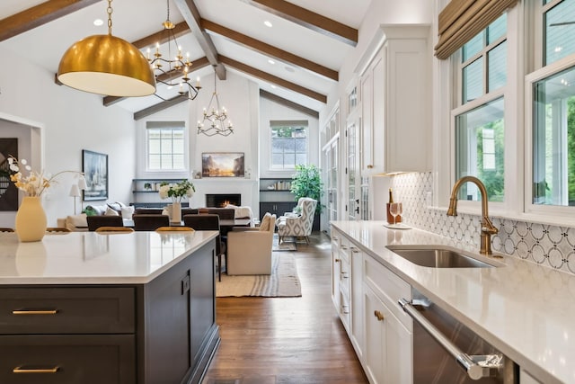 kitchen with white cabinetry, sink, pendant lighting, and a chandelier