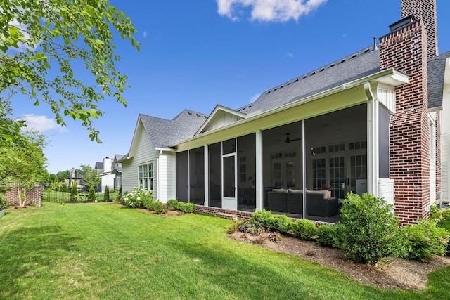 rear view of property with a yard and a sunroom