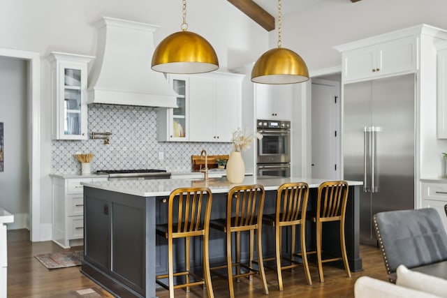 kitchen with stainless steel appliances, premium range hood, and white cabinets