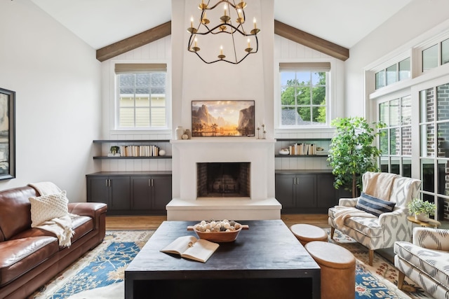 living room with lofted ceiling with beams, a healthy amount of sunlight, and light hardwood / wood-style floors